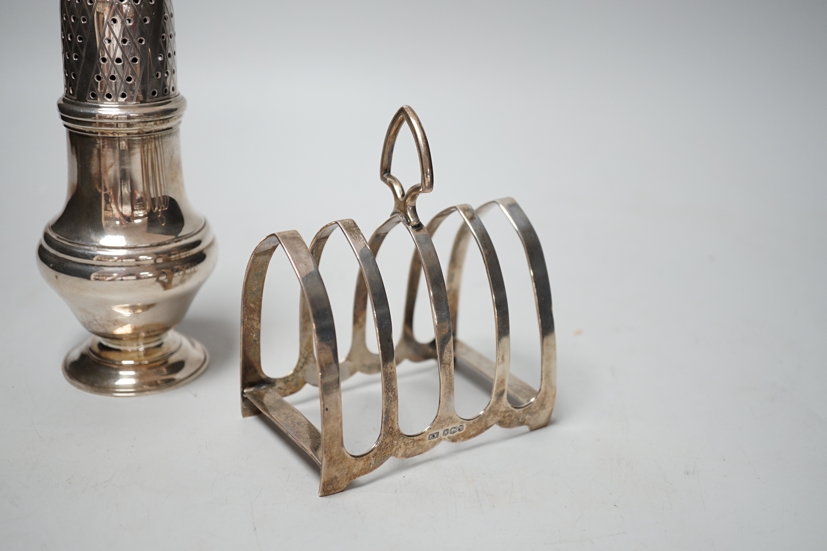 A modern silver sugar caster, 16.5cm and a George V silver toast rack, 8.7oz.